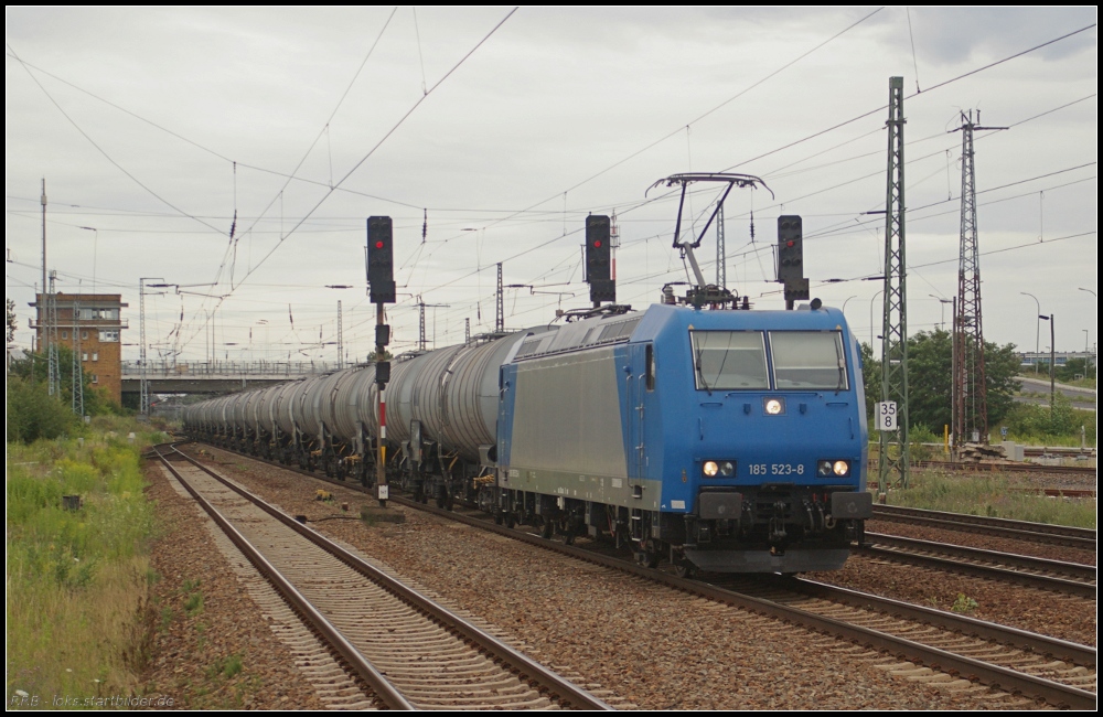 Für HGK ist 185 523-8 im Einsatz und mit einem Kesselzug Richtung Süden unterwegs (gesehen Berlin Schönefeld Flughafen 17.07.2011, ex WLE, ex CFL)