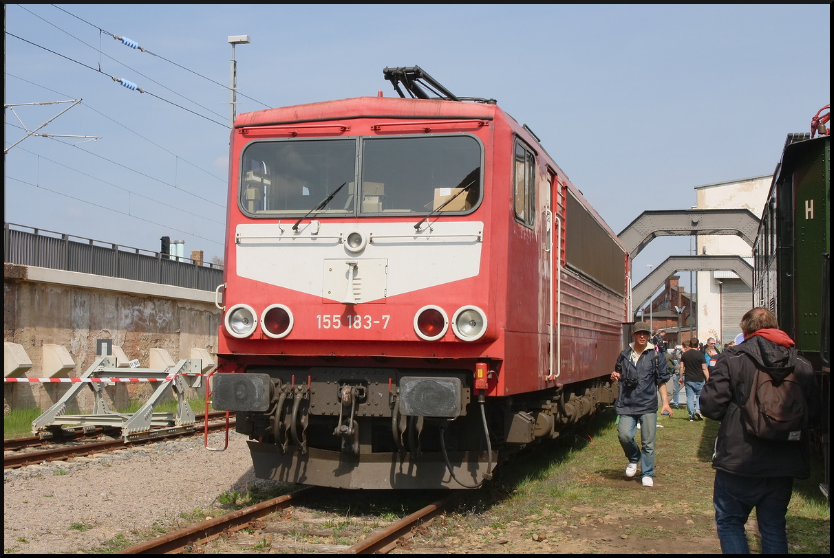 Mit einem Sonderzug kam die Löbauer 155 183. Sie ist Eigen des Unternehmen Maik Ampft Eisenbahndienstleistungen (MAED) und regelmäßig vor Güterzügen zum Einsatz. In besonderen Fällen wie zum 17. Dresdner Dampflokfest zieht sie auch Sonderzüge. Am 12.04.2025 steht sie am Ausziehgleis der Schiebebühne der IG Bw Dresden-Altstadt e.V. und zeigt sich den Besuchern. Diese Seite mit Latz ist Führerstand 2, der Führerstand 1 hat ihn nicht. Die Lok ist in Altrot lackiert (NVR-Nummer 91 80 6 155 183-7 D-MAED).<br>
---<br>
Die Lok wurde 1982 beim VEB Lokomotivbau Elektrotechnische Werke  Hans Beimler  Hennigsdorf (LEW) als 250 183-1 gebaut und erhielt im gleichen Jahr das Bw Erfurt. Die Deutsche Reichsbahn der DDR zeichnete die Lok 1993 dann in 155 183 um und entsprach so dem Baureihenschema der Deutschen Bahn. Im Jahr 2016 kaufte das Unternehmen Maik Ampft Eisenbahndienstleistungen die Lok. Dadurch das sie lange Güterzüge ohne große Probleme ziehen konnte und auch ihre technischen Daten damals überzeugten, erhielt sie die Spitznamen  Energiekontainer  oder auch  Energieriegel .